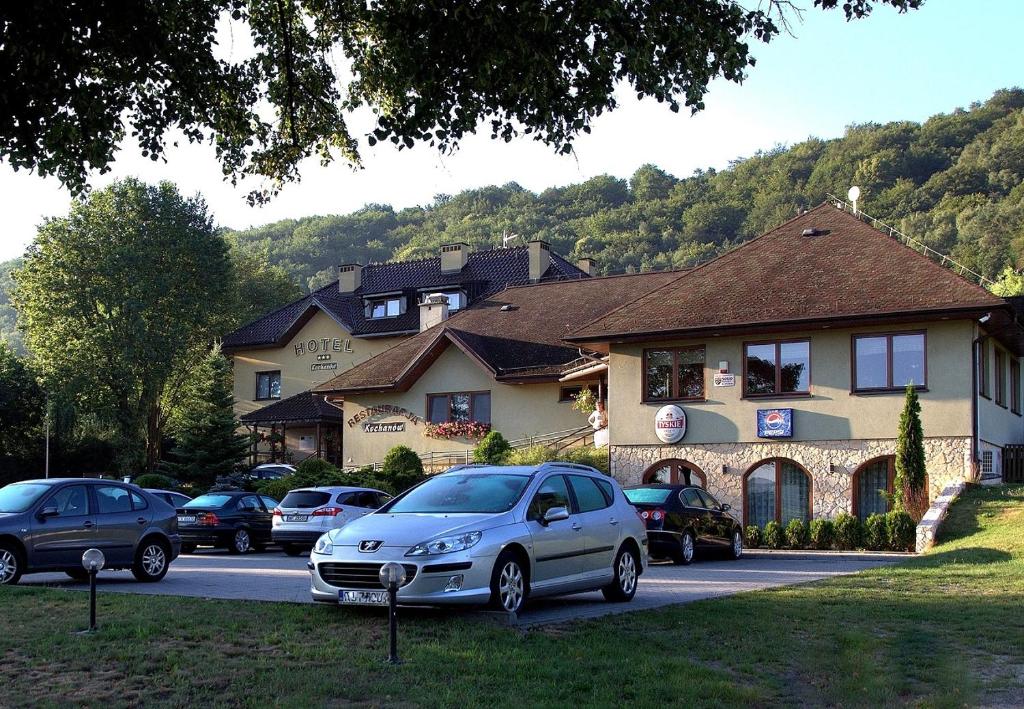 un grupo de autos estacionados frente a una casa en Hotel Kochanów en Kochanów