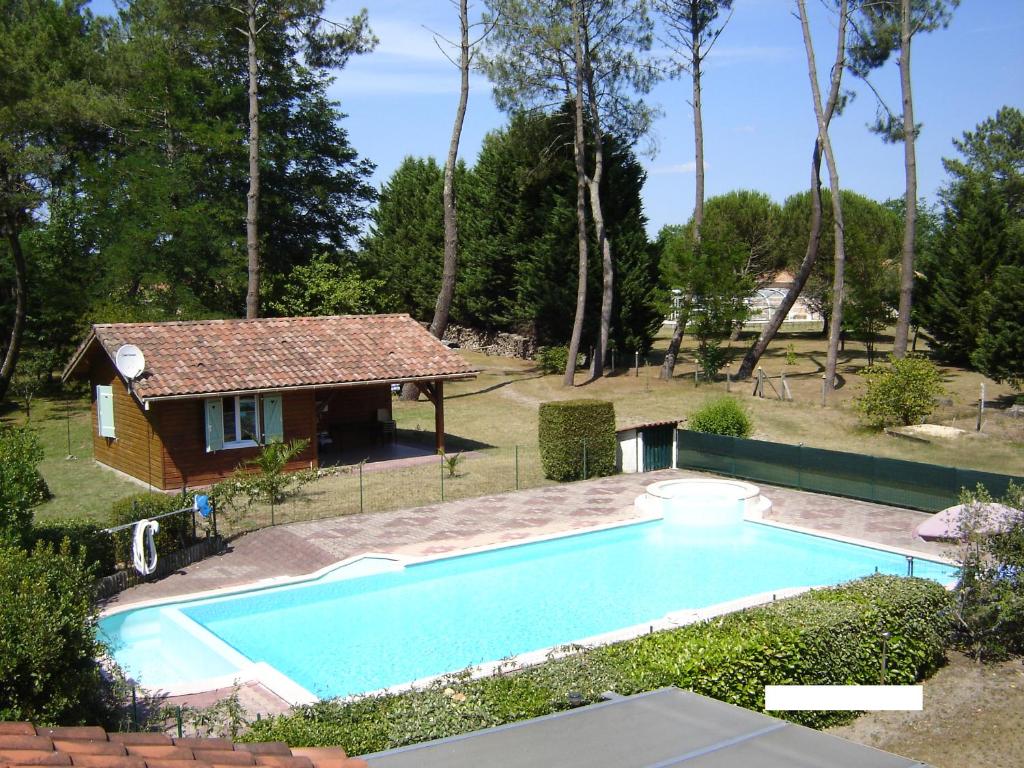 une piscine devant une maison dans l'établissement Chalet Saint Julien en Born, à Saint-Julien-en-Born