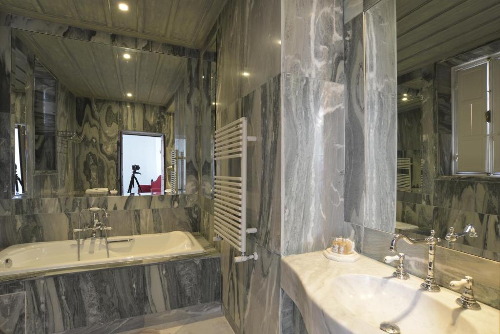 a bathroom with two sinks and a tub and a mirror at Palais Bayram in Tunis