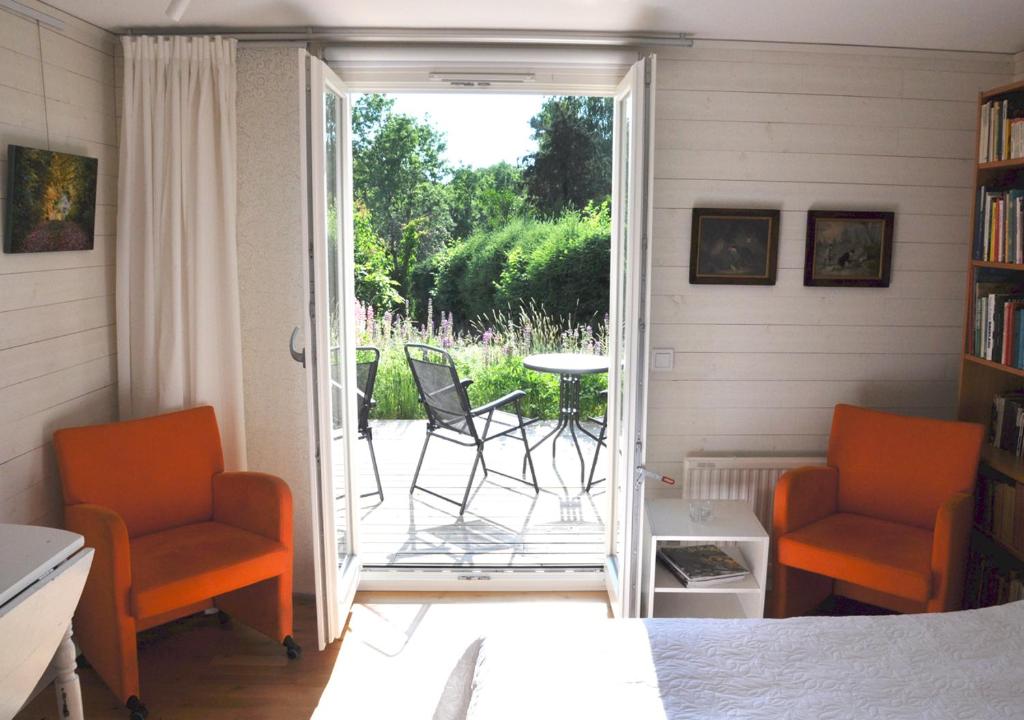 une chambre avec deux chaises et une terrasse avec une table dans l'établissement Room In Ekestad, à Ekestad