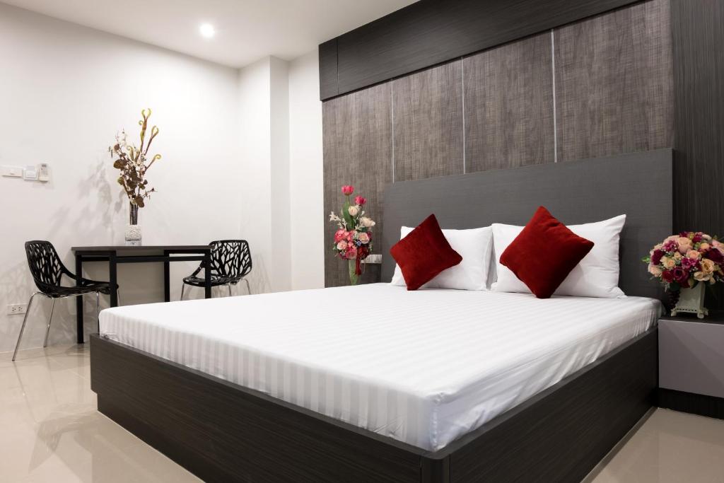 um quarto com uma cama grande e almofadas vermelhas em DB Plus 5 em Bangkok