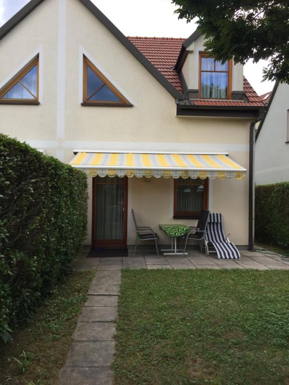 a house with awning and chairs on a patio at Thermen Chalet 85m² in Lutzmannsburg