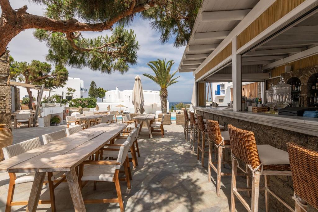 a patio area with tables, chairs and umbrellas at Poseidon Hotel Suites in Mikonos