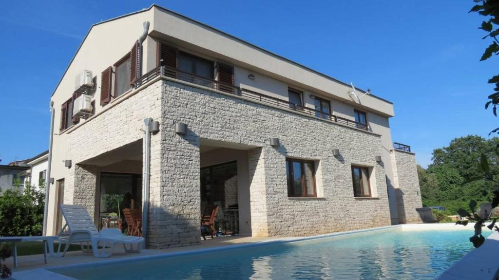 une maison avec une piscine devant dans l'établissement House Mia, à Ližnjan