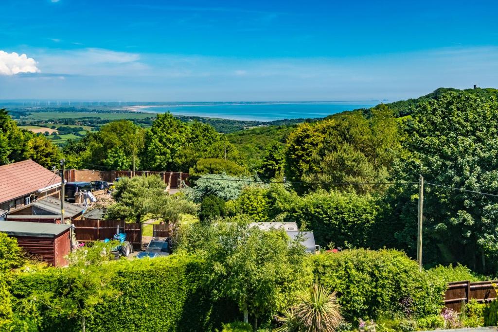 a view of a town with trees and the ocean at Sea View Holiday Flat - Covehurst Bay in Hastings