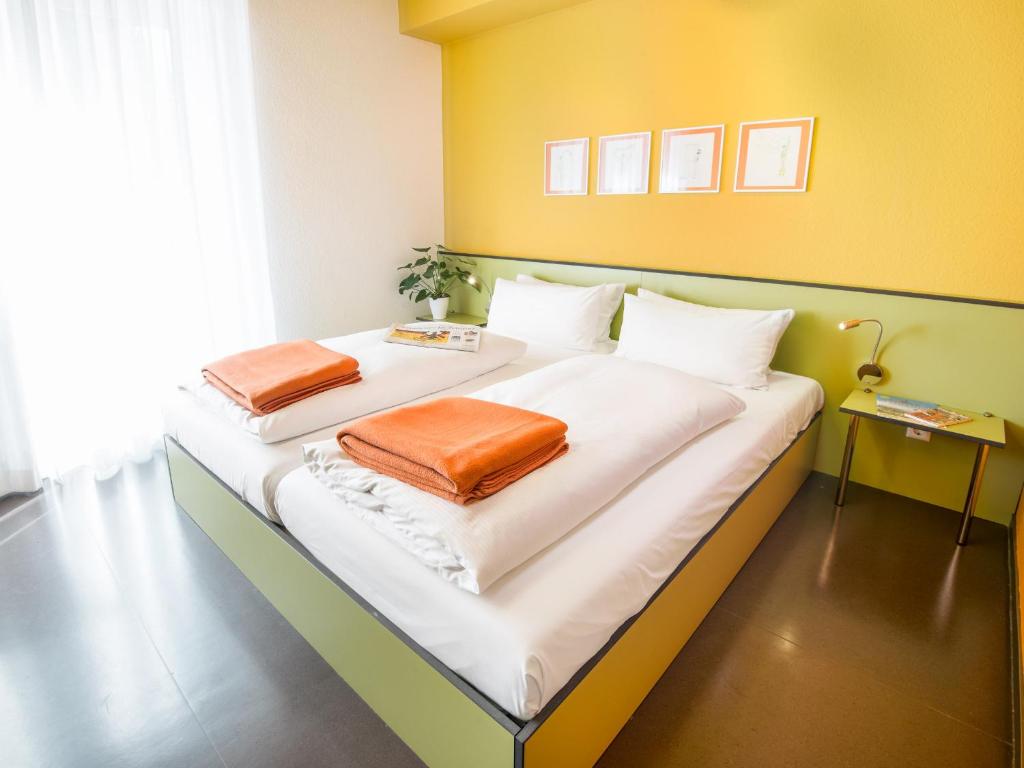 een slaapkamer met een groot bed met 2 kussens erop bij viavelo hotel in Freiburg im Breisgau