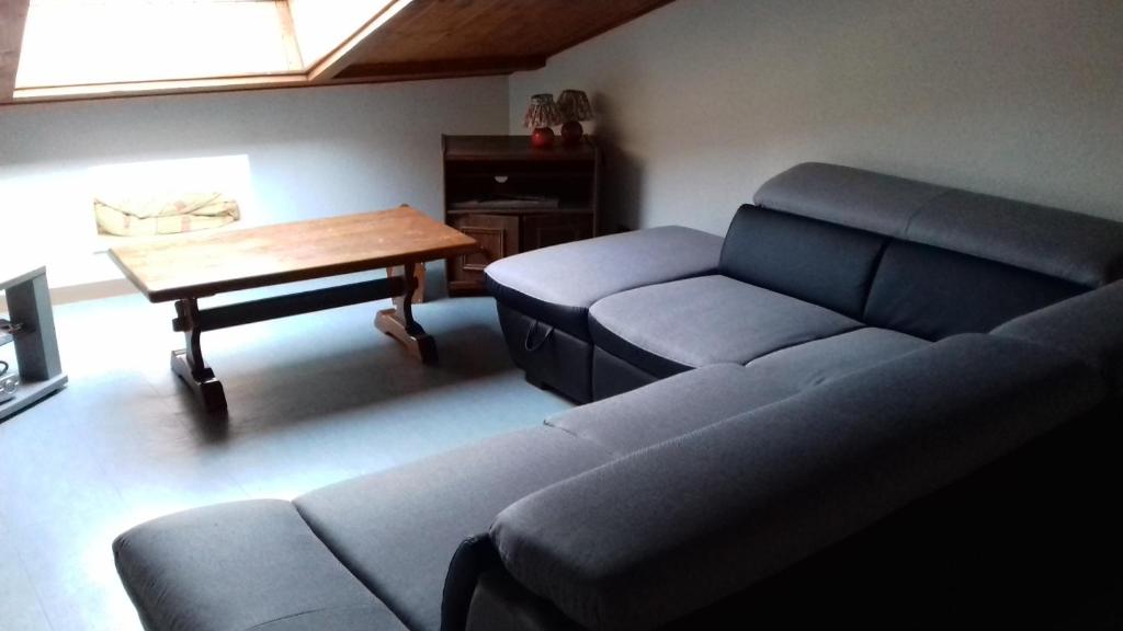 - un salon avec un canapé et une table dans l'établissement Gîte de la Grande Fontaine, à Isches