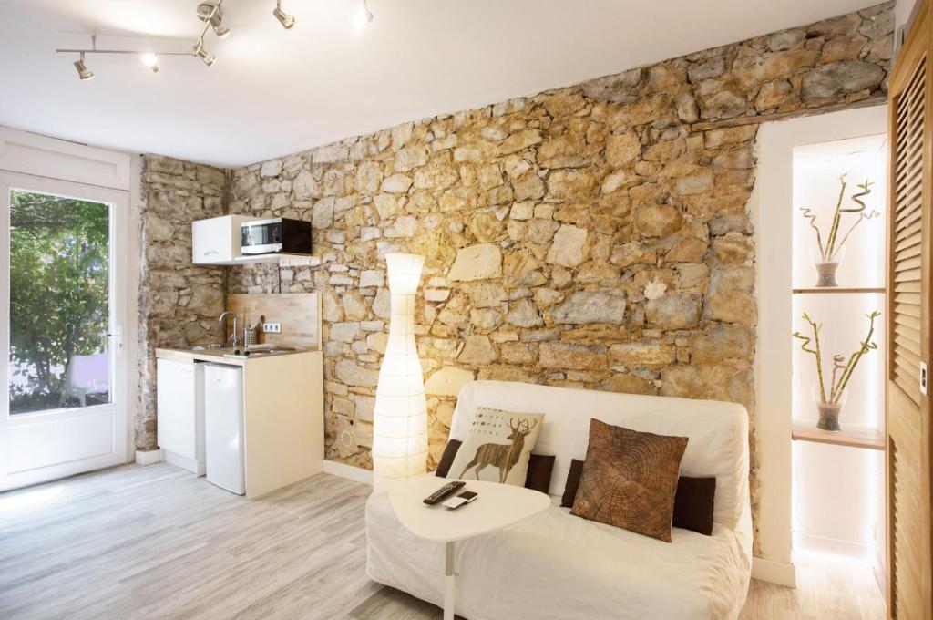 a living room with a stone wall at GregBnb-com - Studio CLIMATISÉ - Terrasse & parking privé in Toulon