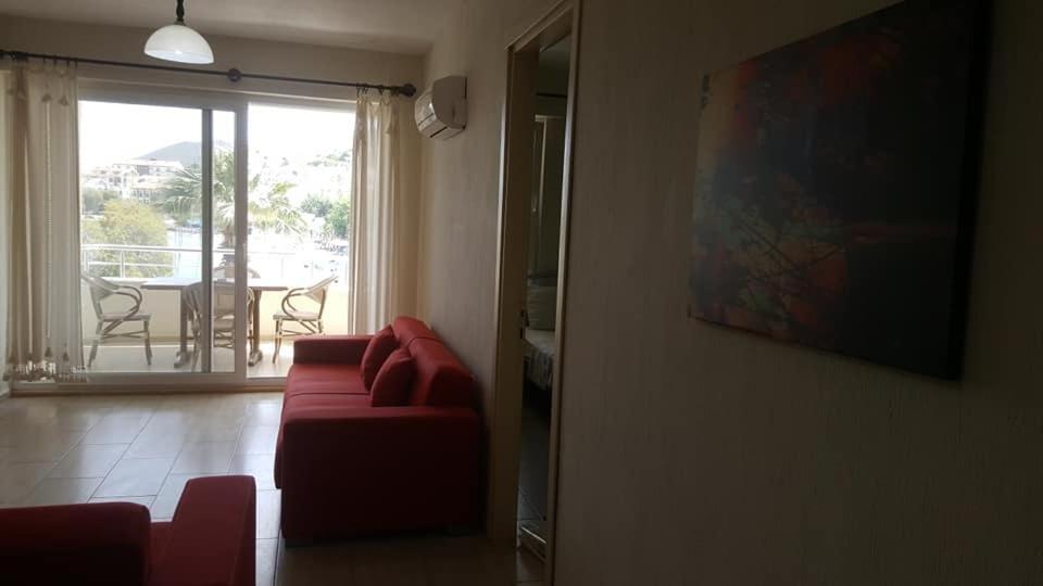 sala de estar con sofá rojo y puerta corredera de cristal en Aydeniz Apart Hotel, en Datça