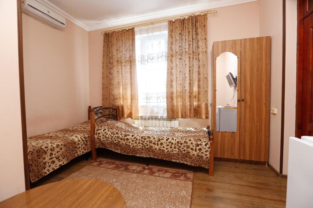 a bedroom with a bed and a window at Guesthouse na ulitze Mimoz 9 in Adler