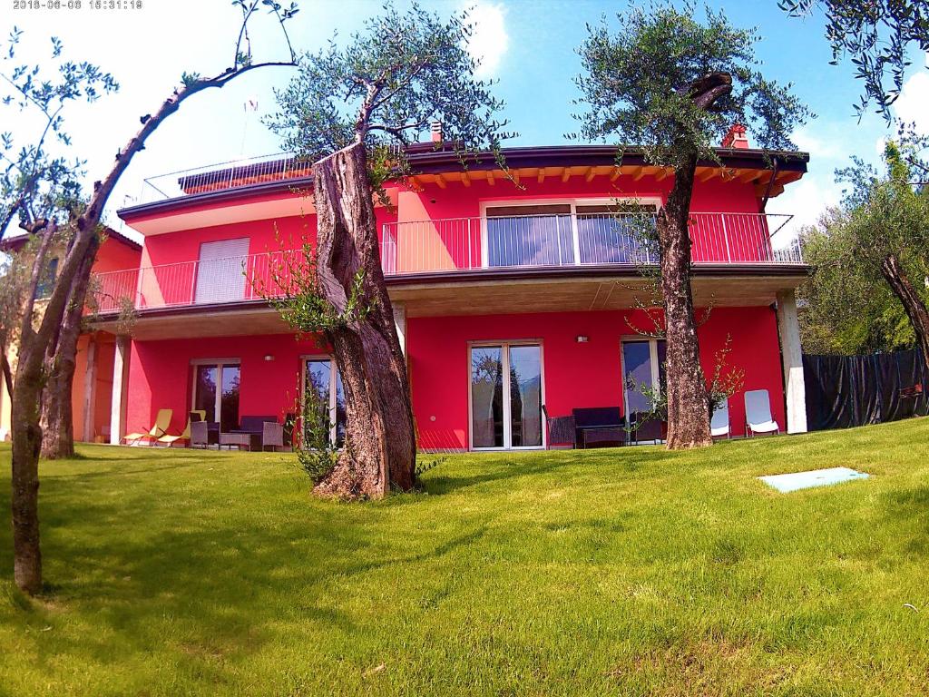 a red house with trees in front of it at Casa Simone in Malcesine