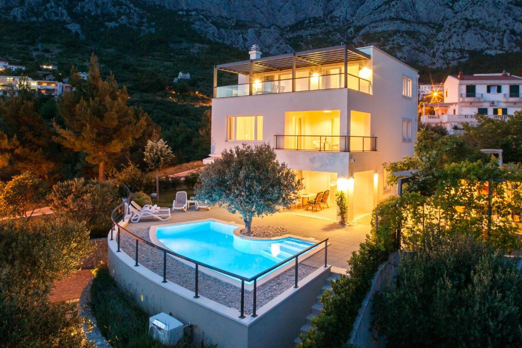 a house with a swimming pool in front of it at Villa Lukić in Makarska