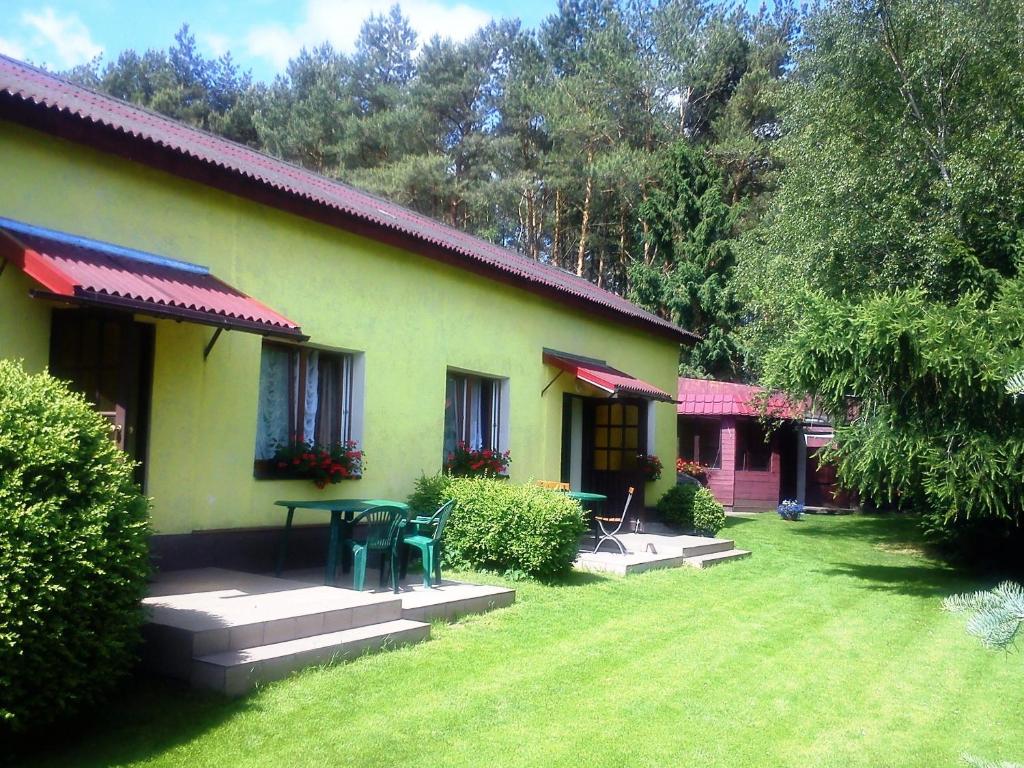 a green house with a table in the yard at Wilcza Chata in Kołczewo