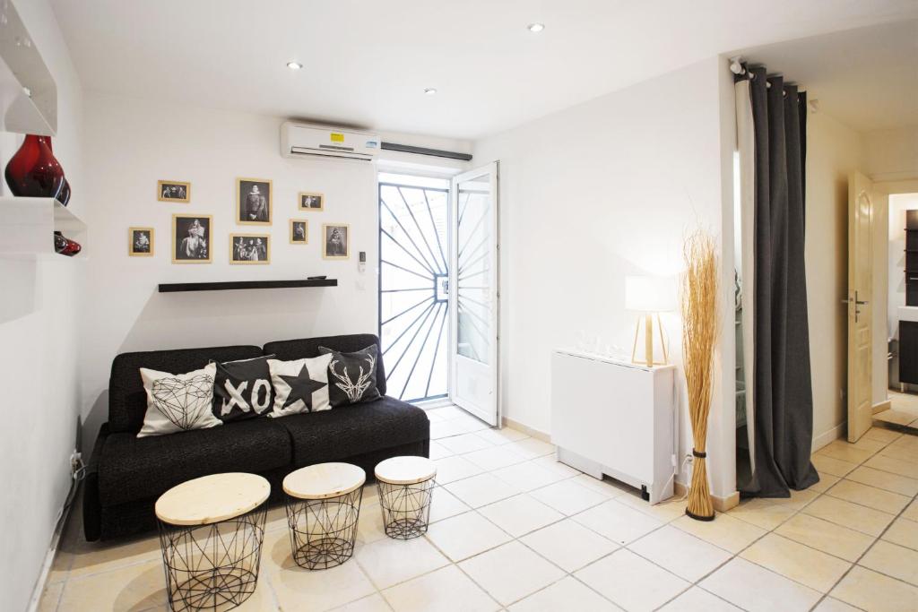 - un salon avec un canapé noir et 2 tables dans l'établissement GregBnb - Studio Cosy - CLIMATISÉ - WIFI - 15min Gare, à Toulon