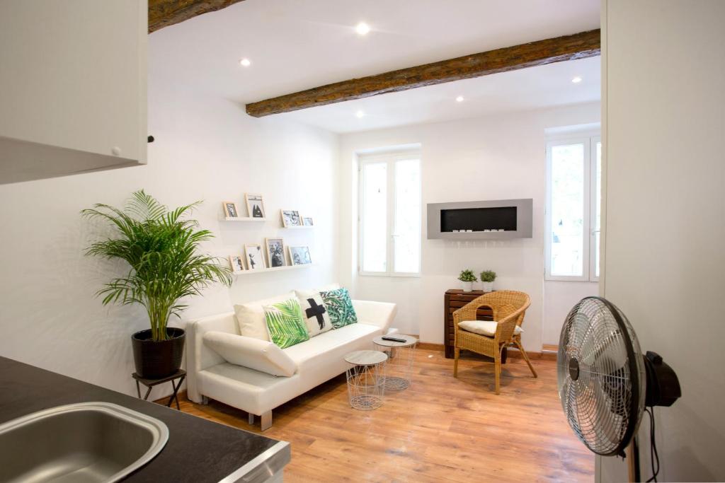 a living room with a white couch and a tv at GregBnb-com - T2 Cosy et design - PARKING INCLUS - WiFi - 15min Gare in Toulon