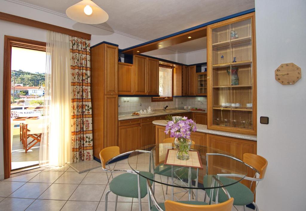 a kitchen with a table with a vase of flowers on it at Lidromi Home (Iris) in Patitiri
