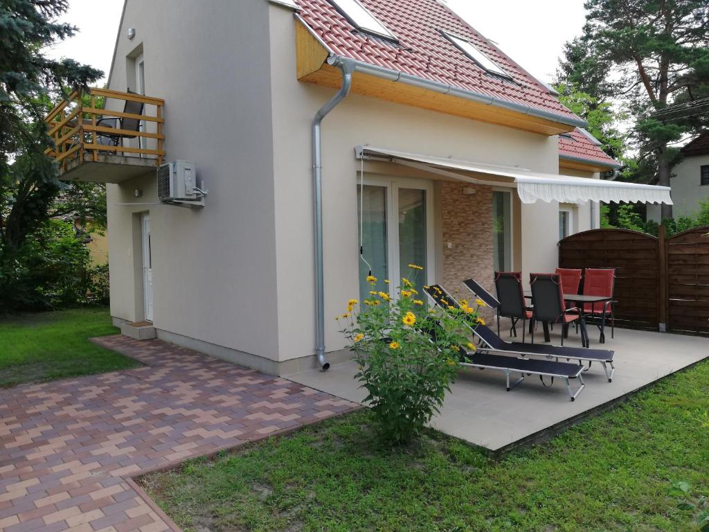 a house with a patio with chairs and a table at Fenyves Ferienhaus 1 **** in Balatonfenyves