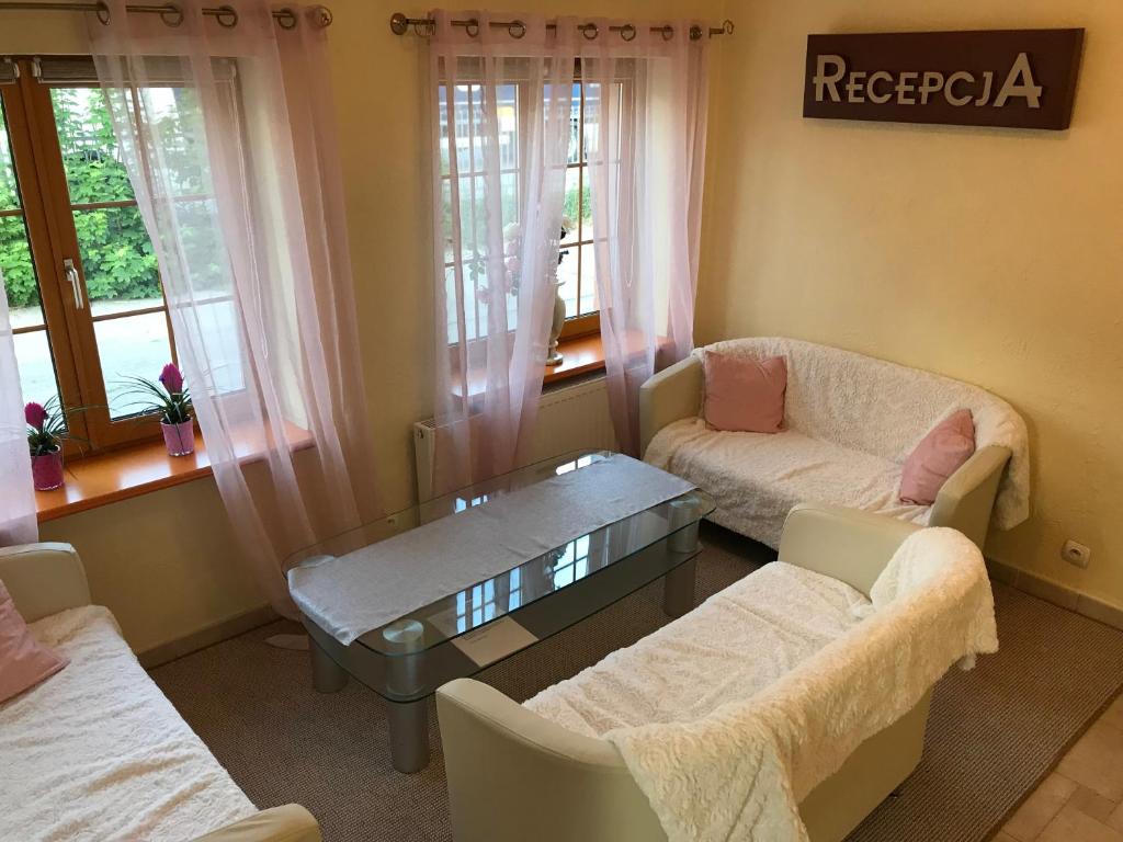 a living room with a couch and a coffee table at Pensjonat Belona in Dziwnów