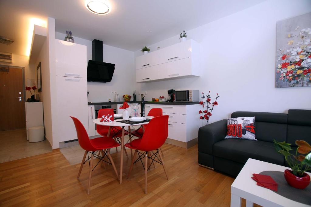 - un salon avec une table et des chaises rouges dans l'établissement Apartment West, à Rijeka