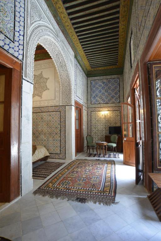 a room with a rug on the floor and an archway at Palais Bayram in Tunis