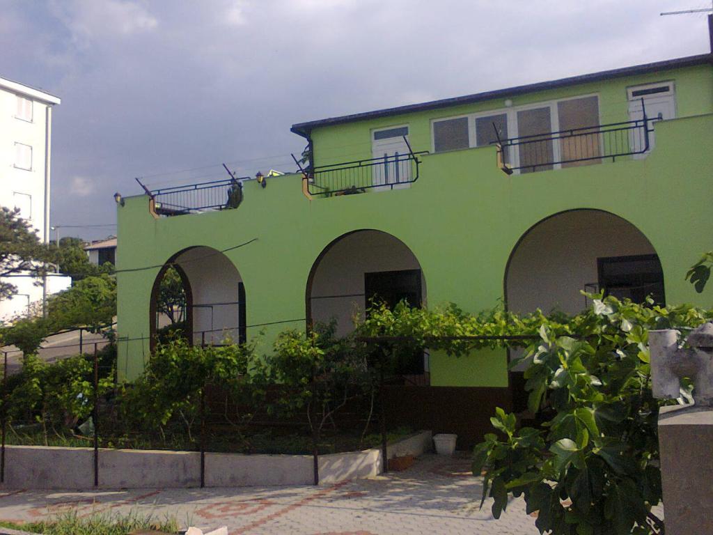 a green building with arches on the side of it at Apartmani Ana Novi V. - studio in Novi Vinodolski
