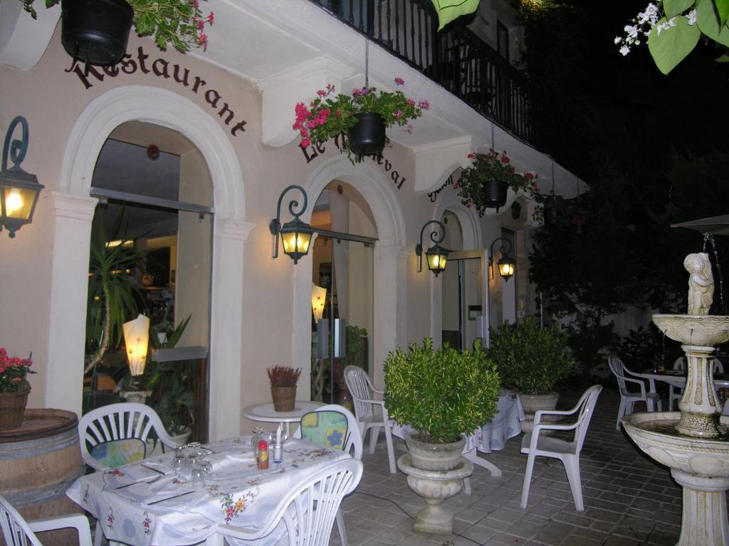 a restaurant with tables and chairs in front of a building at Appart'Hôtel Les Tilleuls in Saint-Macaire