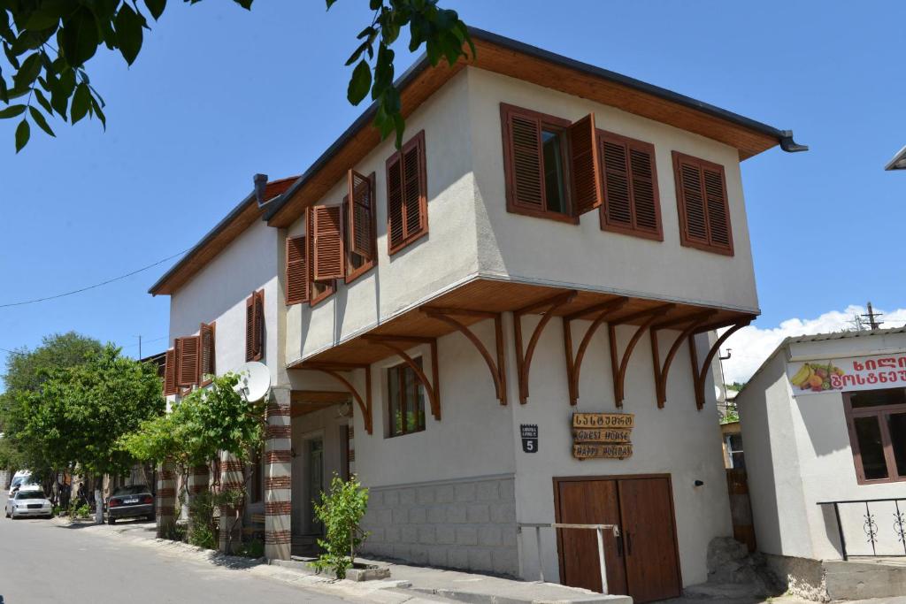 a building with brown shuttered windows on a street at Happy Holiday in Akhaltsikhe