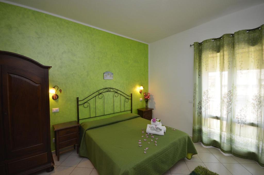 サン・ヴィート・ロ・カーポにあるtre passi dal mareの緑のベッドルーム(ベッド1台、窓付)