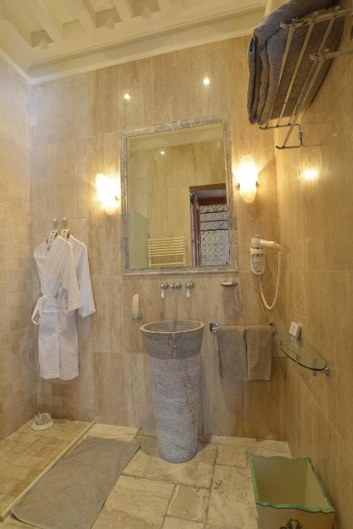 a bathroom with a sink and a mirror and towels at Palais Bayram in Tunis