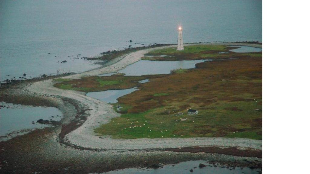 an island with a lighthouse in the middle of the ocean at Mama`s By The Sea B&B in Clark's Harbour