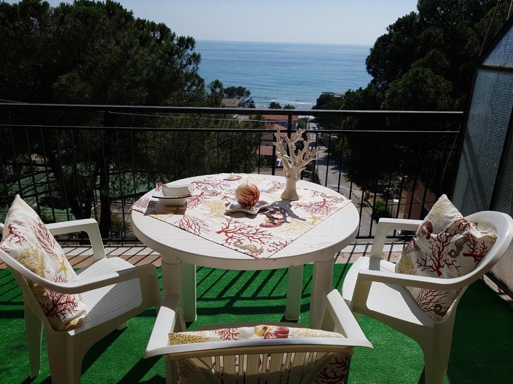 a white table with two chairs and a table with a view at Casa Laura in Acciaroli