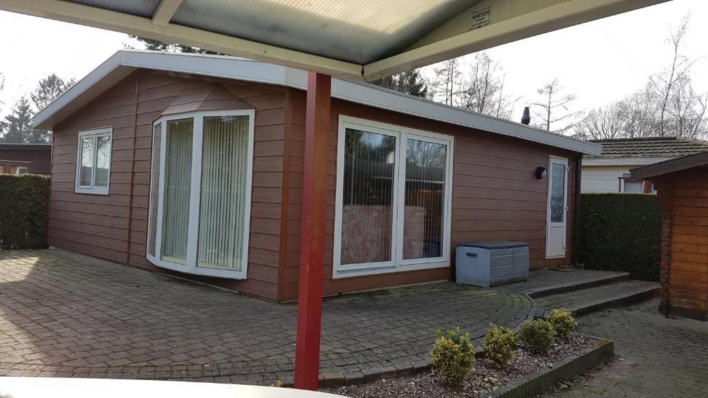 a small house with a porch and a patio at Deluxe Holiday Home in Putten