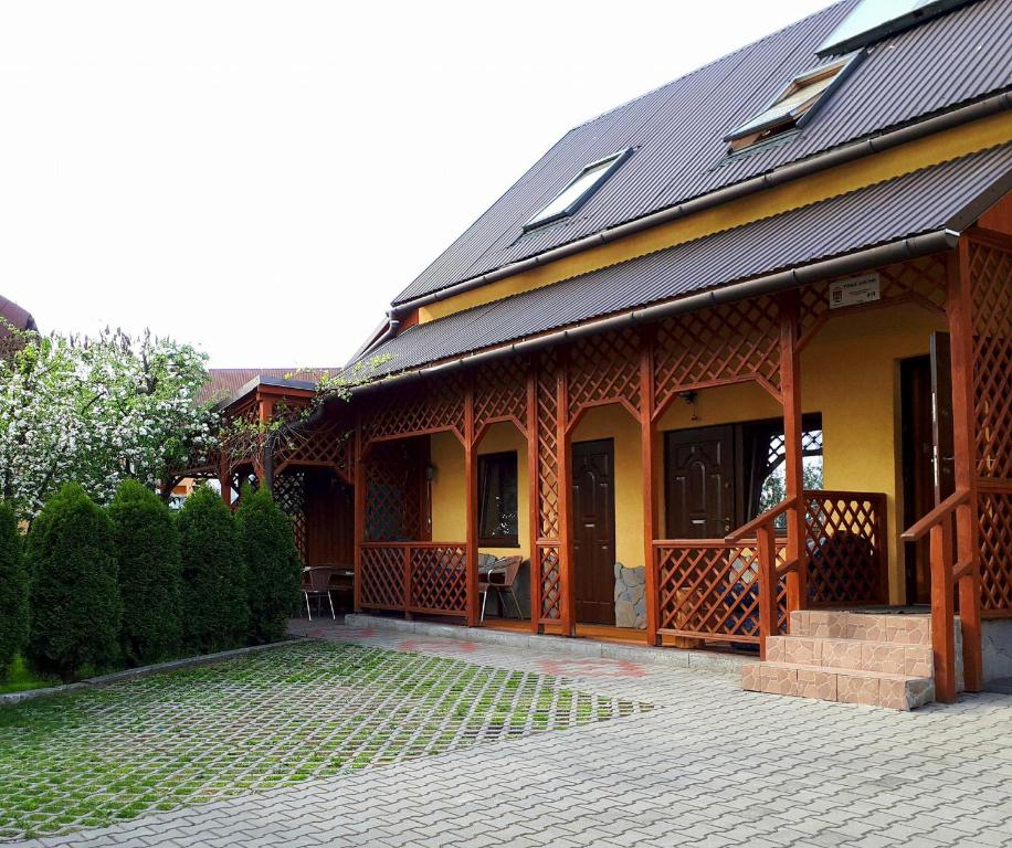 a house with a black roof and a patio at Noclegi u Zosi in Maniowy