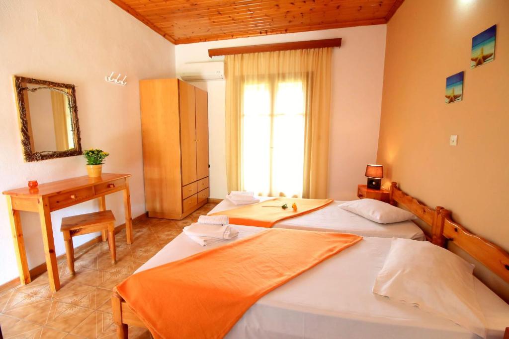 sypialnia z 2 łóżkami, biurkiem i oknem w obiekcie Romeo & Juliet w mieście Perivólion