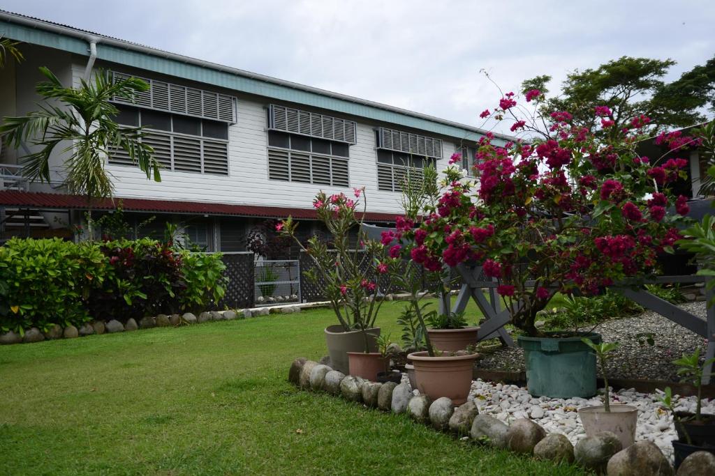 a garden with flowers in pots in front of a building at Access Units in Lungga