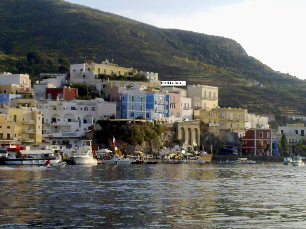 um grupo de edifícios e barcos na água em Hotel La Baia em Ponza