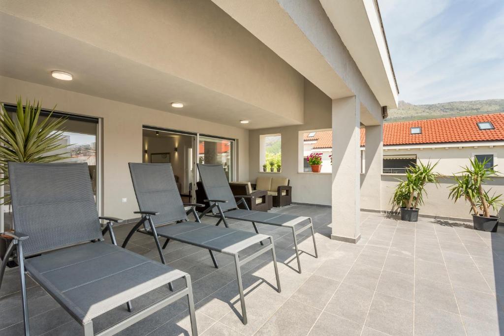 - une rangée de chaises assises sur une terrasse dans l'établissement Beach Residence with pool and sea view, à Podstrana