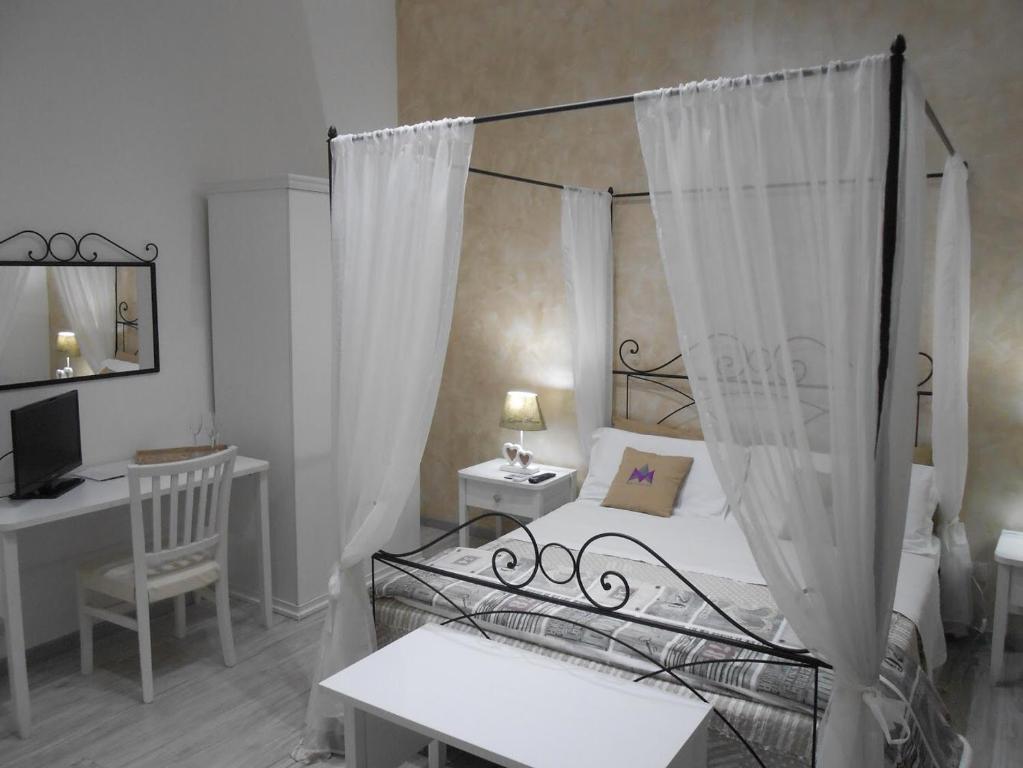 a bedroom with a bed and a desk with a computer at Mattandre in Monteroni di Lecce