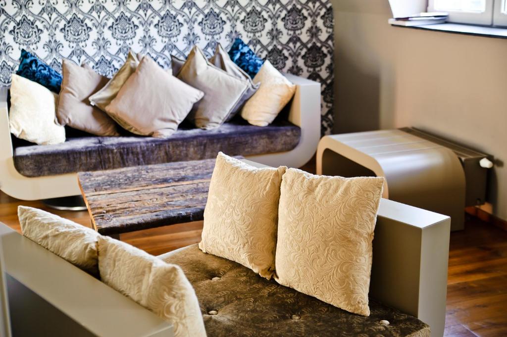 a couch with pillows on it in a living room at Hotel Rosenmeer in Mönchengladbach