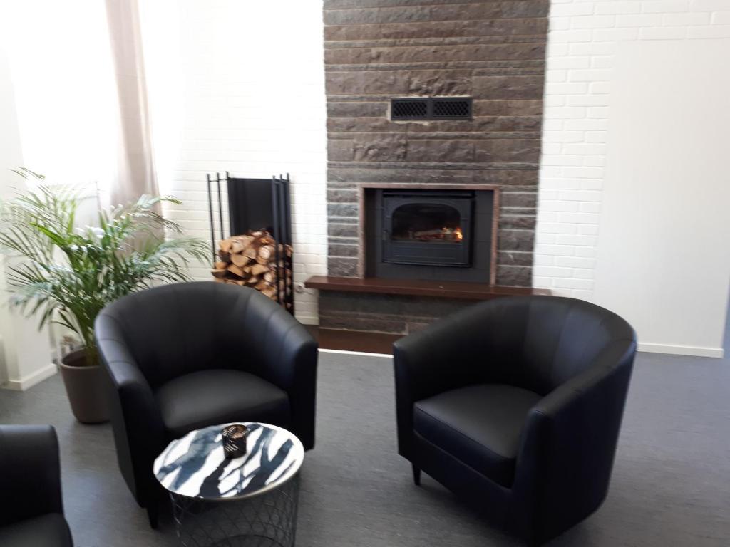 a living room with two chairs and a fireplace at STF Kalix Vandrarhem in Kalix