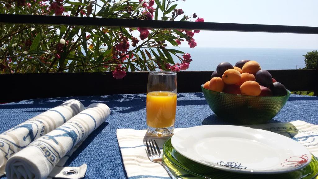 a table with a bowl of fruit and a glass of orange juice at Apartment DiLen in Dobra Voda
