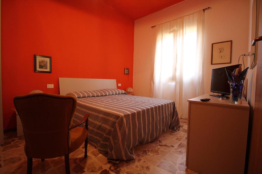 a bedroom with a bed and a desk with a television at Affittacamere Da Giorgia in Sampieri