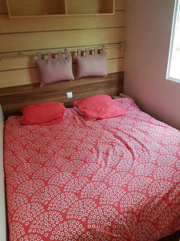 1 dormitorio con 1 cama con sábanas y almohadas rojas en Irm hacienda en Onzain