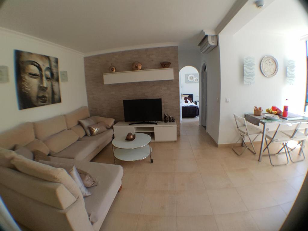 a living room with a couch and a tv at Tara apartment in Playa del Ingles