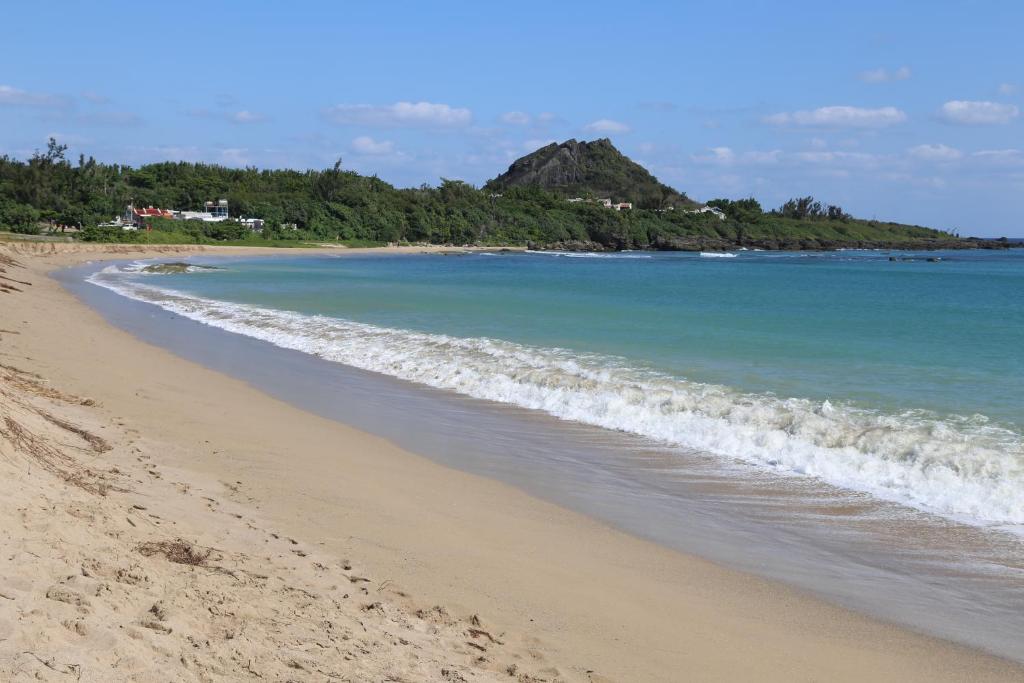 a sandy beach with waves coming in from the ocean at Kenting Waterfront Hotel in Kenting