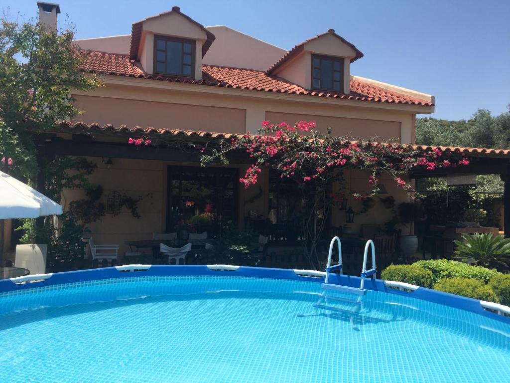 a swimming pool in front of a house at Rafina great feeling villa in Rafina