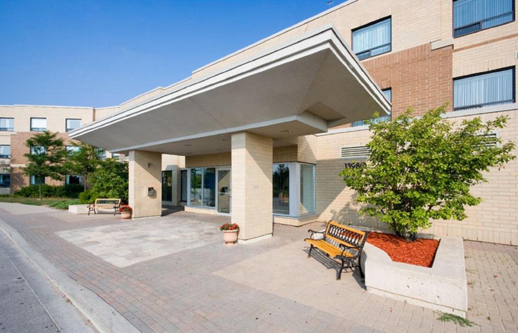 einer Bank vor einem Gebäude in der Unterkunft Residence & Conference Centre - King City in King City