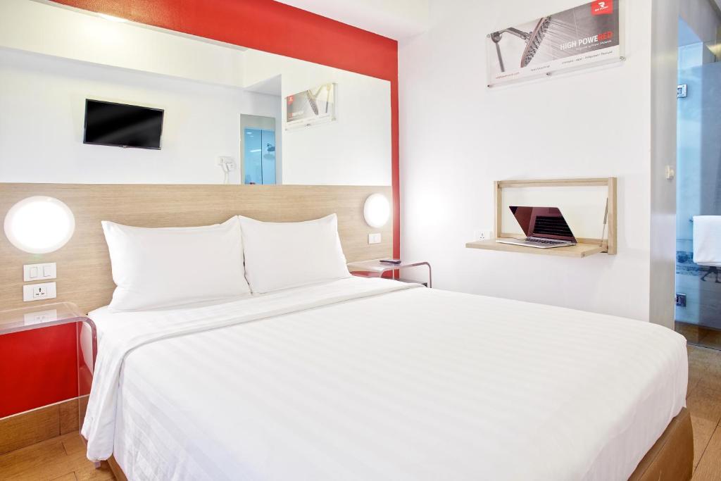 Un dormitorio con una gran cama blanca y una ventana en Red Planet Ortigas, en Manila