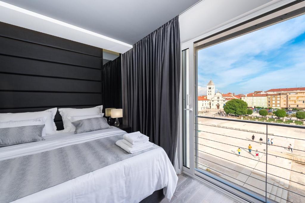 1 dormitorio con cama y ventana grande en Artis accommodation, en Zadar