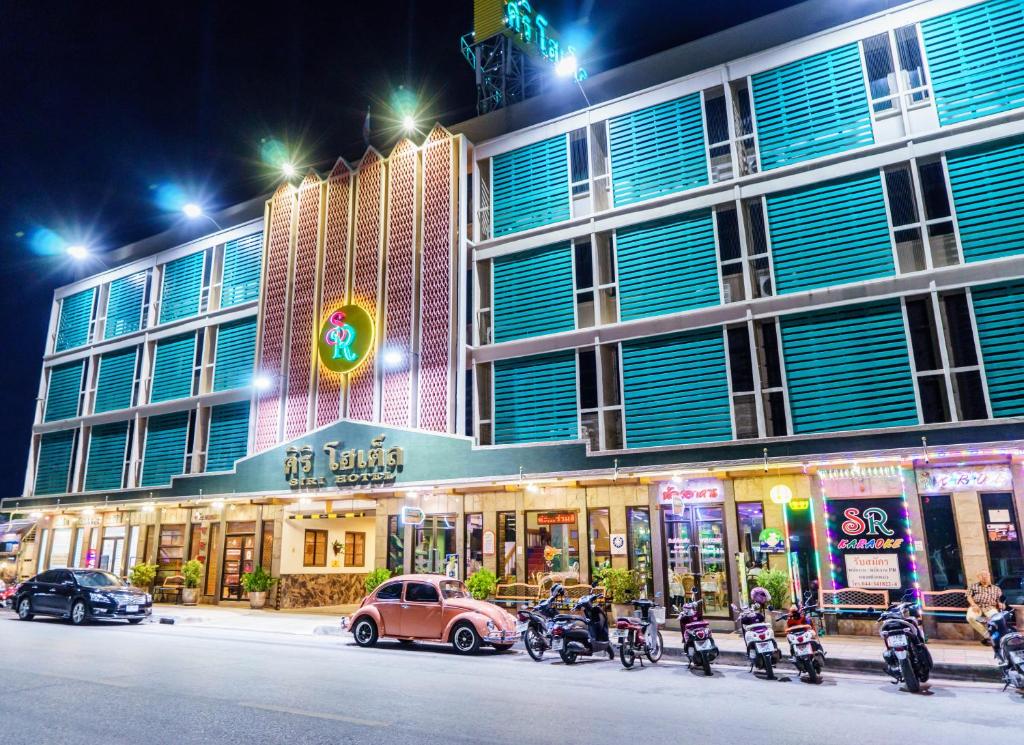 un grupo de motocicletas estacionadas frente a un edificio en Siri Hotel, en Nakhon Ratchasima